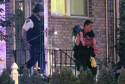 Cops carry Orlik's daughter out of the house.
